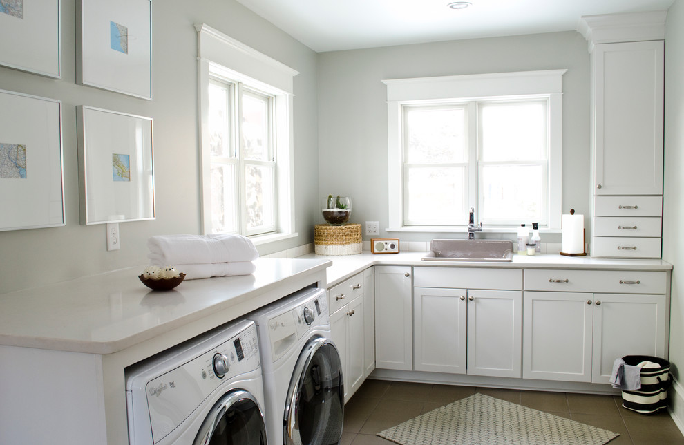 Foto på en mellanstor vintage vita l-formad tvättstuga, med en nedsänkt diskho, skåp i shakerstil, vita skåp, grå väggar, klinkergolv i keramik och en tvättmaskin och torktumlare bredvid varandra