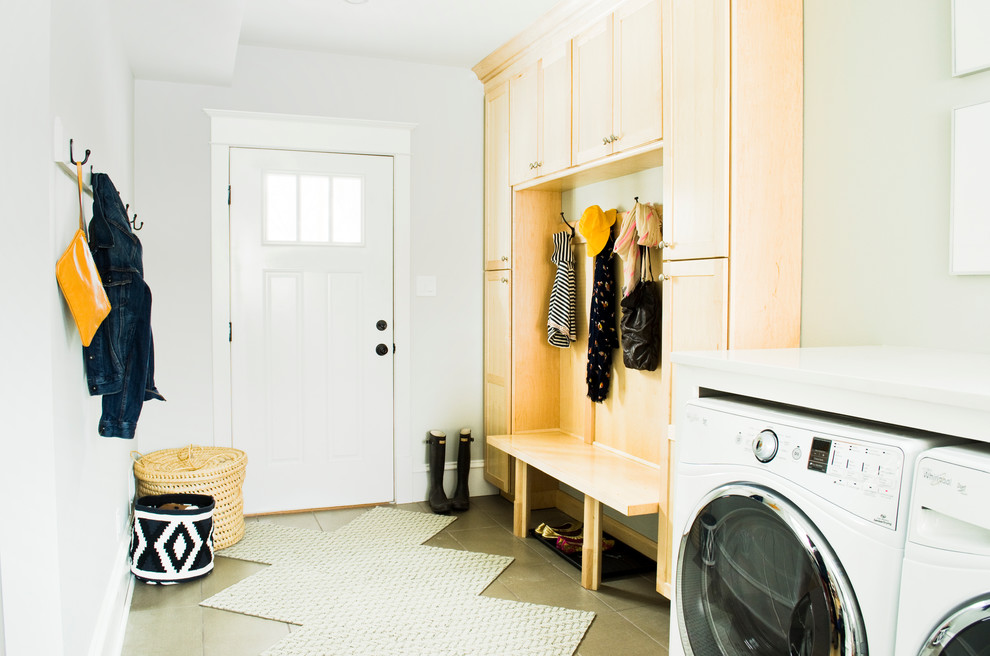 Immagine di una lavanderia multiuso tradizionale di medie dimensioni con ante in stile shaker, ante in legno chiaro, pareti bianche, pavimento con piastrelle in ceramica e lavatrice e asciugatrice affiancate