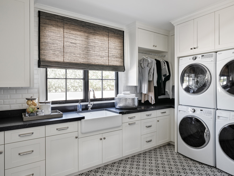 Diseño de cuarto de lavado en L clásico con fregadero sobremueble, armarios estilo shaker, puertas de armario blancas, suelo multicolor y encimeras negras