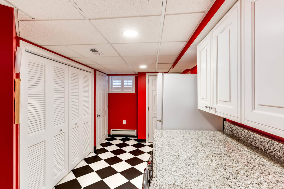 ワシントンD.C.にあるお手頃価格の小さなトラディショナルスタイルのおしゃれな洗濯室 (ll型、レイズドパネル扉のキャビネット、白いキャビネット、御影石カウンター、赤い壁、セラミックタイルの床、左右配置の洗濯機・乾燥機、白い床) の写真