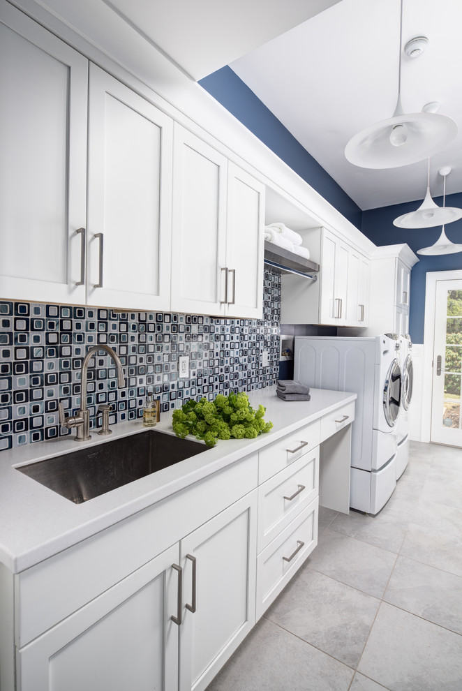 Large contemporary galley separated utility room in New York with a single-bowl sink, shaker cabinets, white cabinets, blue walls, ceramic flooring, a side by side washer and dryer and composite countertops.