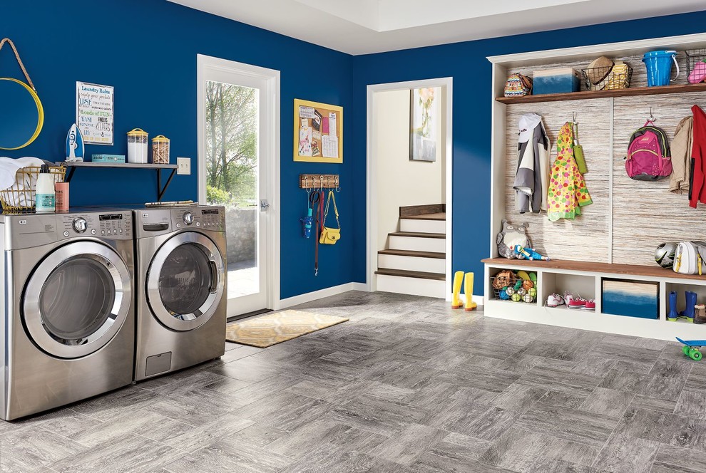 Immagine di una grande lavanderia multiuso minimalista con lavatrice e asciugatrice affiancate, pareti blu, pavimento in vinile e pavimento grigio