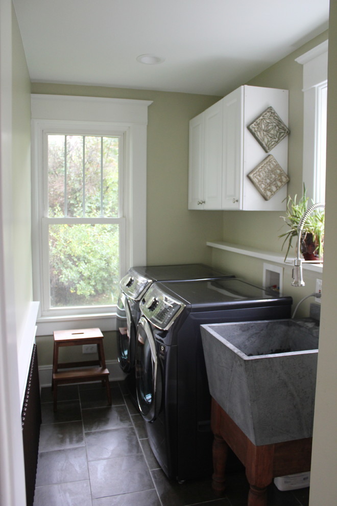 Einzeilige, Kleine Klassische Waschküche mit Waschbecken, profilierten Schrankfronten, weißen Schränken, Waschmaschine und Trockner nebeneinander, beiger Wandfarbe und Schieferboden in Sonstige