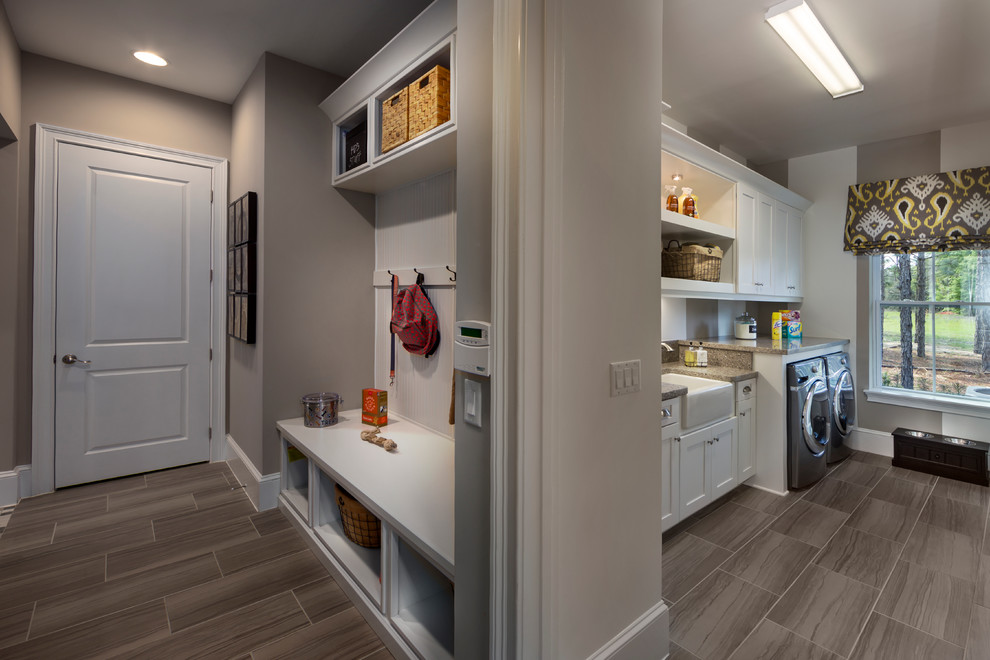 Example of a huge transitional single-wall ceramic tile utility room design in Tampa with a farmhouse sink, shaker cabinets, white cabinets, laminate countertops, beige walls and a side-by-side washer/dryer