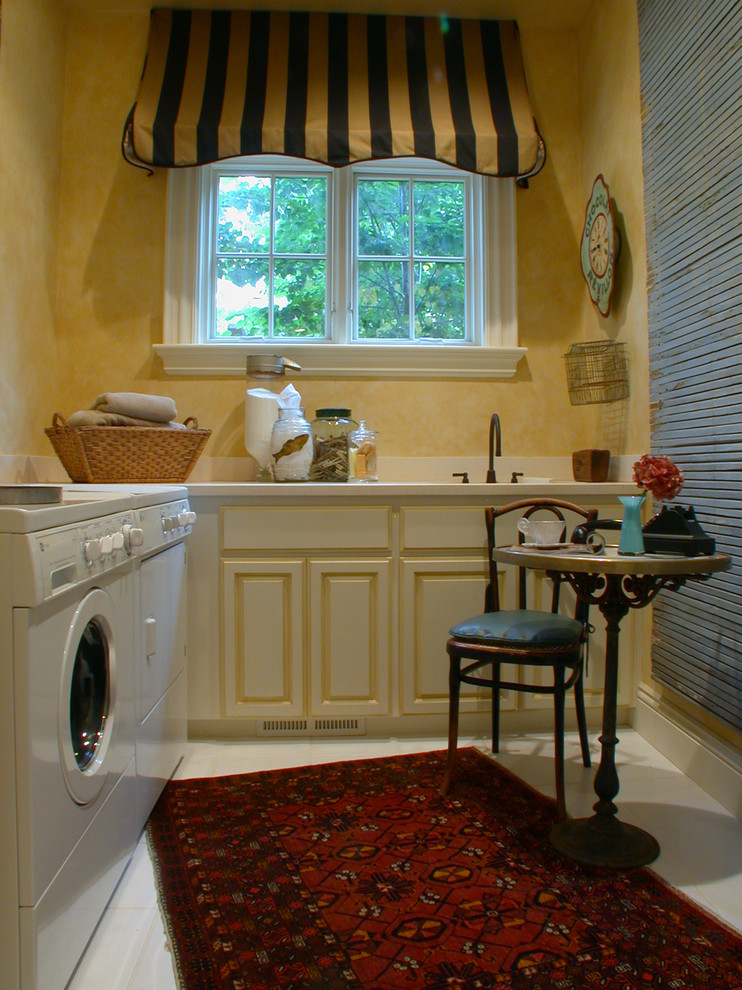 Foto på ett mellanstort eklektiskt parallellt grovkök, med luckor med upphöjd panel, skåp i slitet trä, en tvättmaskin och torktumlare bredvid varandra och beige väggar