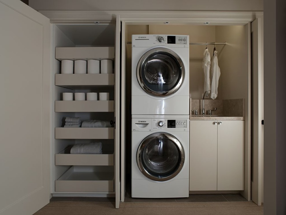 Inspiration for a small contemporary single-wall laundry closet remodel in San Francisco with a stacked washer/dryer, an undermount sink, flat-panel cabinets, beige cabinets and beige walls
