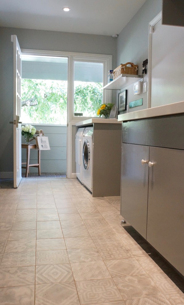 Photo of a medium sized classic galley utility room in San Francisco with a submerged sink, flat-panel cabinets, grey cabinets, engineered stone countertops, grey walls, ceramic flooring, a side by side washer and dryer, grey floors and white worktops.