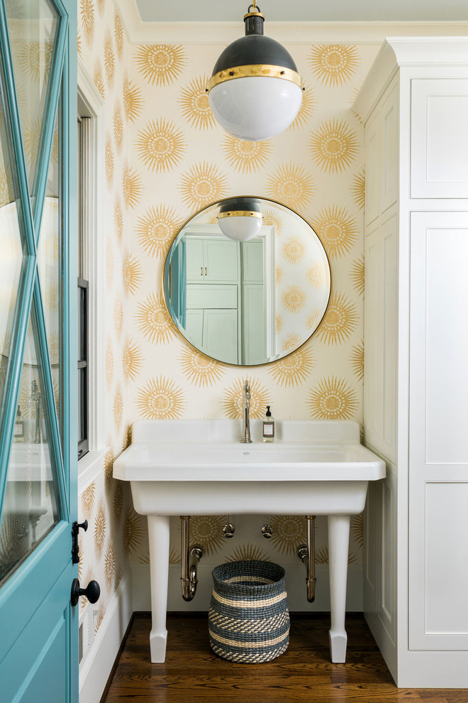 Exempel på en klassisk tvättstuga, med en allbänk, luckor med profilerade fronter, vita skåp, flerfärgade väggar, mörkt trägolv och brunt golv