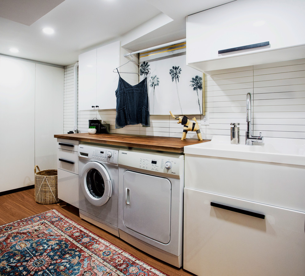 Design ideas for a small modern utility room in Toronto with flat-panel cabinets.
