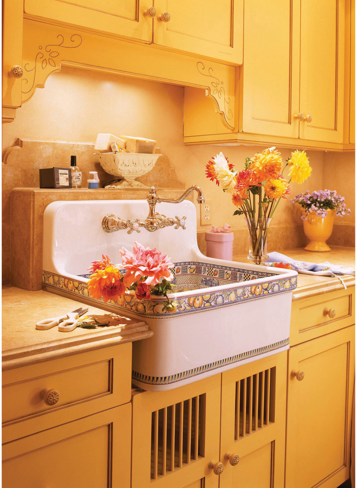 Inredning av ett medelhavsstil mellanstort linjärt grovkök, med en allbänk, luckor med infälld panel, gula skåp, granitbänkskiva, beige väggar, beiget golv, klinkergolv i porslin och en tvättmaskin och torktumlare bredvid varandra