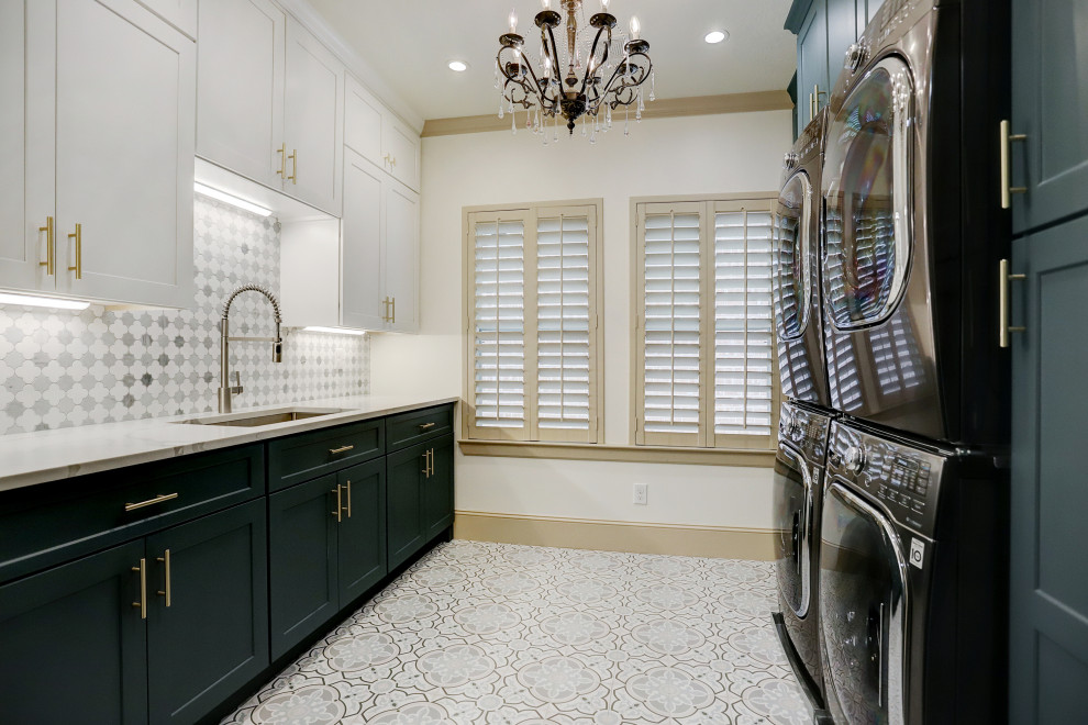 Example of a large classic galley ceramic tile and multicolored floor dedicated laundry room design in Houston with a drop-in sink, shaker cabinets, turquoise cabinets, quartzite countertops, multicolored backsplash, ceramic backsplash, white walls, a stacked washer/dryer and white countertops