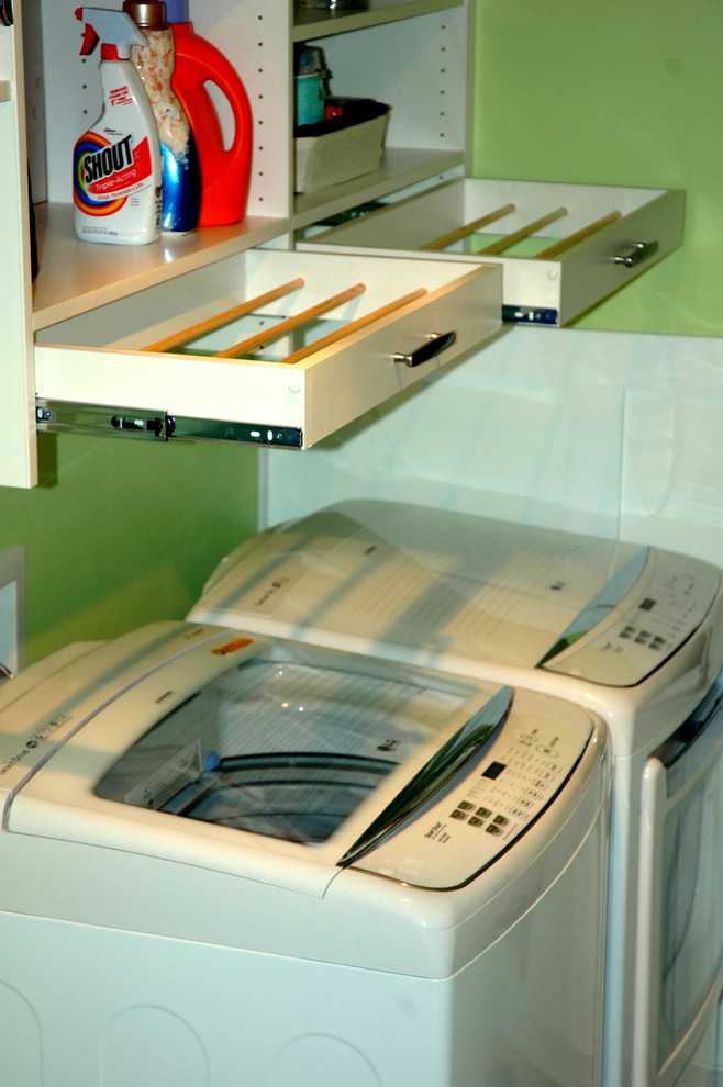Idéer för att renovera en stor funkis linjär tvättstuga enbart för tvätt, med släta luckor, vita skåp, gröna väggar, linoleumgolv och en tvättmaskin och torktumlare bredvid varandra