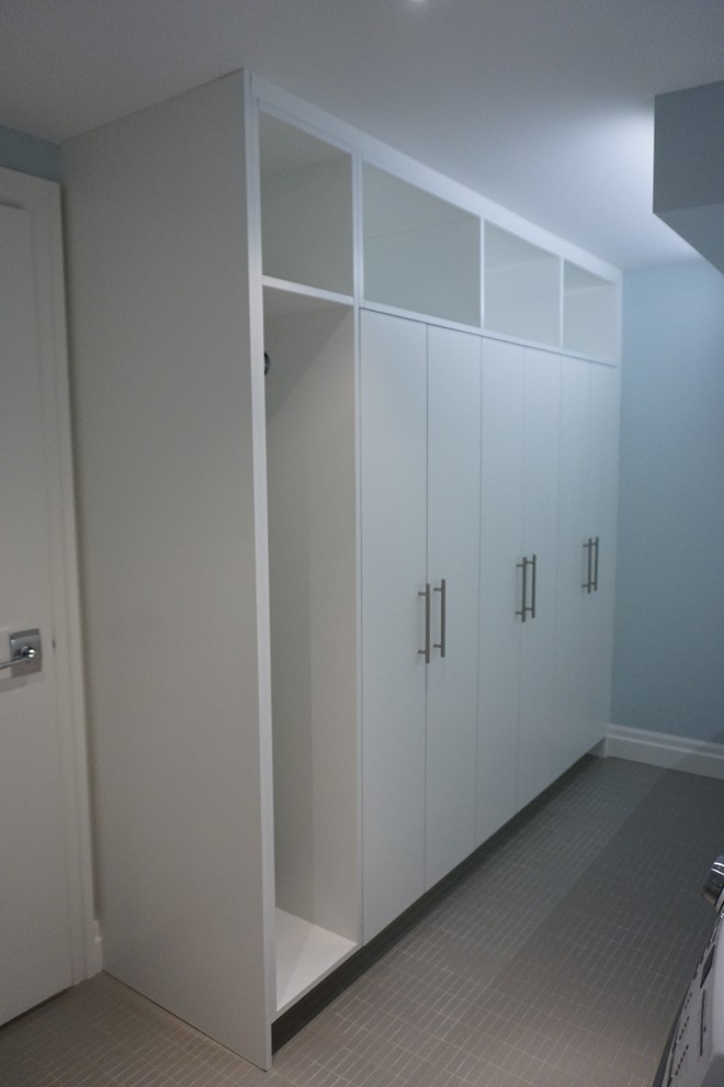 Photo of a modern galley utility room in Toronto with a submerged sink, flat-panel cabinets, white cabinets, engineered stone countertops, blue walls, porcelain flooring and a side by side washer and dryer.