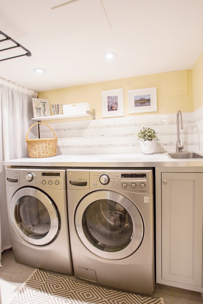 Einzeilige, Kleine Klassische Waschküche mit Einbauwaschbecken, Schrankfronten im Shaker-Stil, grauen Schränken, Laminat-Arbeitsplatte, gelber Wandfarbe, Porzellan-Bodenfliesen und Waschmaschine und Trockner nebeneinander in Toronto