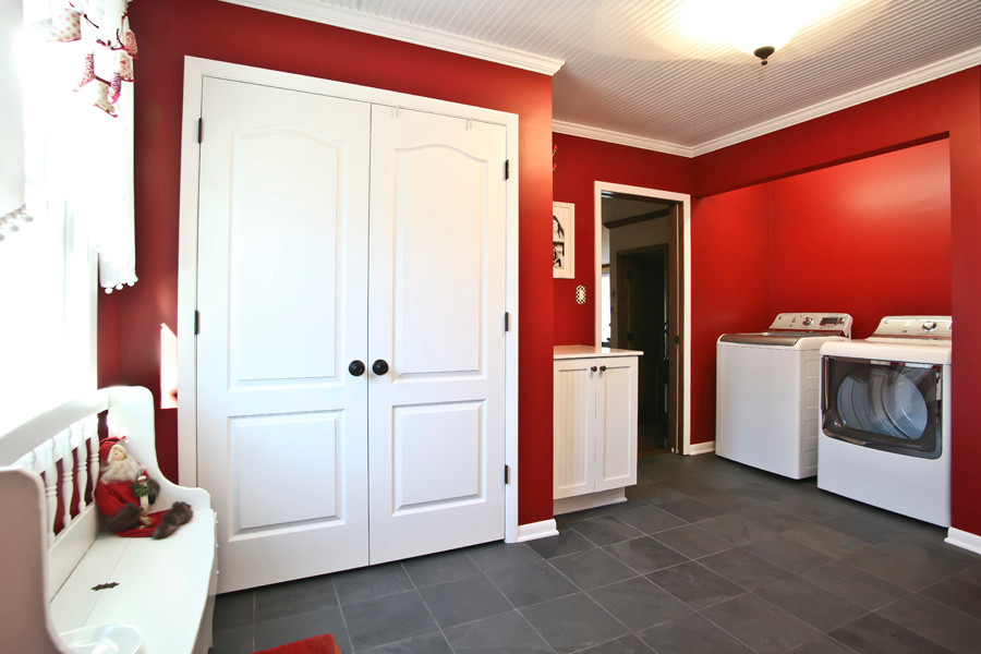 Idéer för att renovera en mellanstor amerikansk tvättstuga enbart för tvätt, med skåp i shakerstil, vita skåp, röda väggar, skiffergolv och en tvättmaskin och torktumlare bredvid varandra