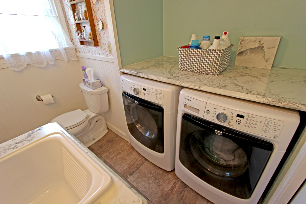 Foto di una piccola lavanderia multiuso country con lavello da incasso, ante con riquadro incassato, ante bianche, top in laminato, pareti verdi e lavatrice e asciugatrice affiancate
