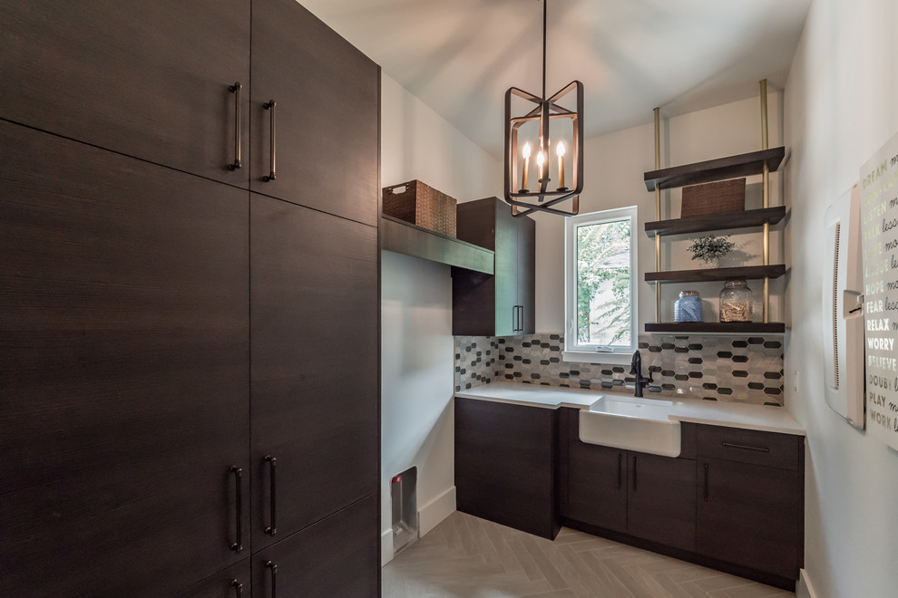 Large traditional utility room in Orlando with a belfast sink, flat-panel cabinets, brown cabinets, engineered stone countertops, white walls, porcelain flooring, a side by side washer and dryer and white worktops.