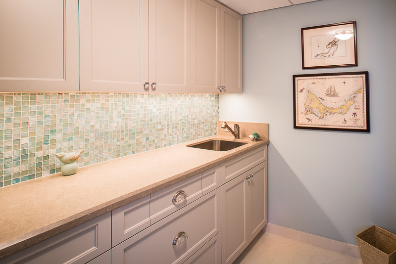 Inspiration for a mid-sized transitional single-wall ceramic tile and beige floor utility room remodel in Houston with an undermount sink, beaded inset cabinets, white cabinets, limestone countertops and blue walls