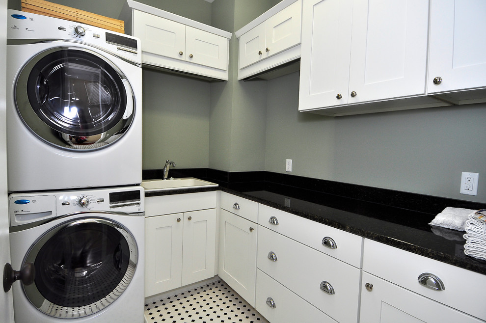 Exempel på en mellanstor klassisk l-formad tvättstuga enbart för tvätt, med en nedsänkt diskho, skåp i shakerstil, vita skåp, granitbänkskiva, grå väggar, klinkergolv i porslin och en tvättpelare