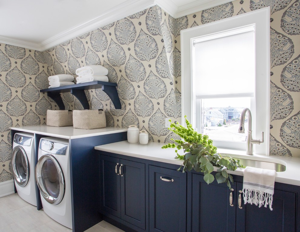 Esempio di una sala lavanderia costiera con lavello sottopiano, ante a filo, ante blu, pareti multicolore, lavatrice e asciugatrice affiancate, pavimento bianco e top bianco
