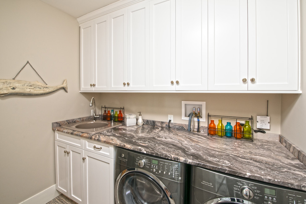 Utility room - mid-sized transitional galley medium tone wood floor utility room idea in Boston with a drop-in sink, raised-panel cabinets, white cabinets, marble countertops, beige walls and a side-by-side washer/dryer