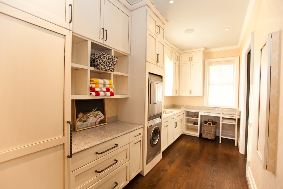Photo of a coastal utility room in Raleigh with a stacked washer and dryer and brown floors.
