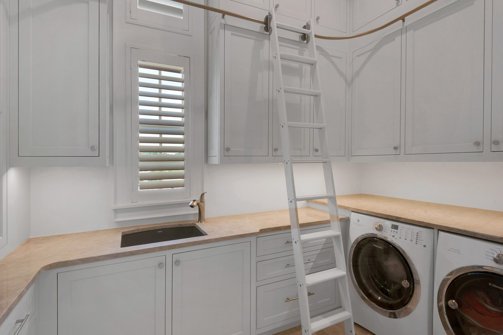 Laundry room - large coastal laundry room idea in Miami with an undermount sink, white walls and a side-by-side washer/dryer