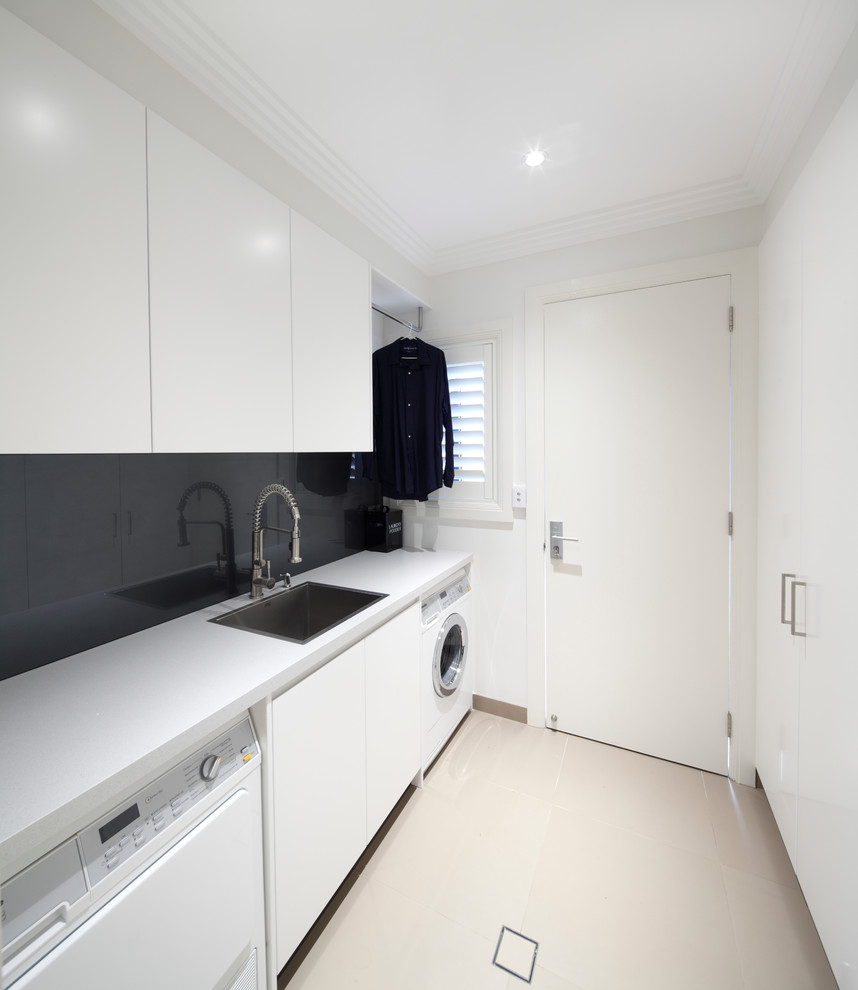 Zweizeilige, Große Moderne Waschküche mit integriertem Waschbecken, flächenbündigen Schrankfronten, weißen Schränken, Quarzit-Arbeitsplatte, weißer Wandfarbe, Porzellan-Bodenfliesen, beigem Boden und weißer Arbeitsplatte in Sydney