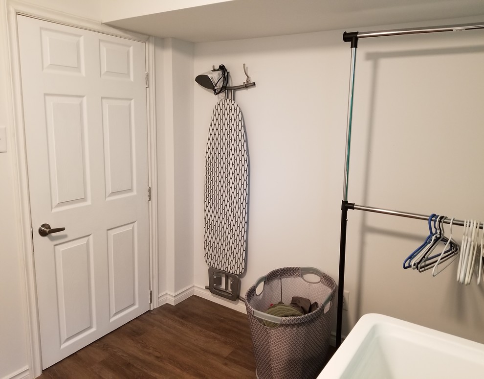 Immagine di una lavanderia con pavimento in vinile, lavatrice e asciugatrice affiancate e pavimento marrone