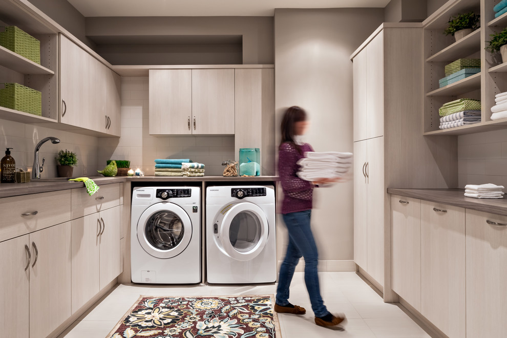 Large trendy u-shaped utility room photo in Toronto with an undermount sink, flat-panel cabinets, beige walls, a side-by-side washer/dryer, laminate countertops and white cabinets