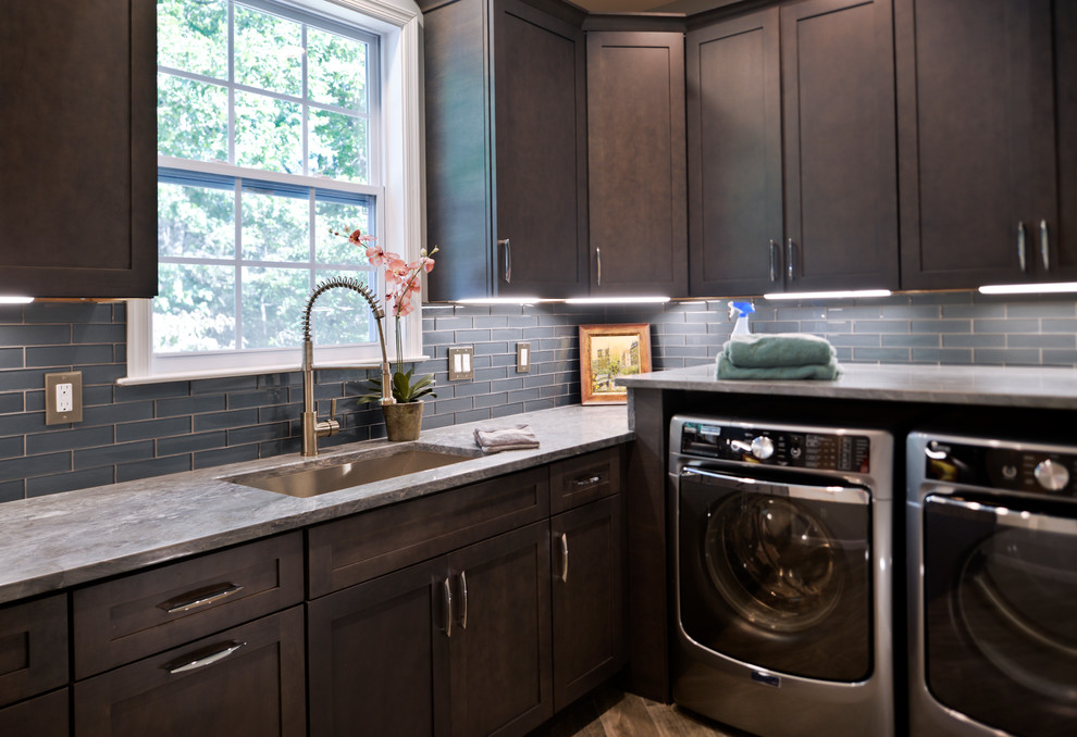 Design ideas for a medium sized modern l-shaped utility room in DC Metro with a submerged sink, flat-panel cabinets, black cabinets, quartz worktops, grey walls, a side by side washer and dryer and grey floors.