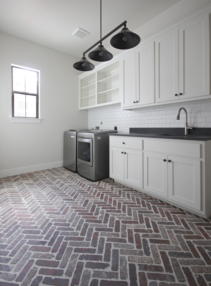 Expansive farmhouse separated utility room in Austin with shaker cabinets, white cabinets, brick flooring, a side by side washer and dryer and multi-coloured floors.