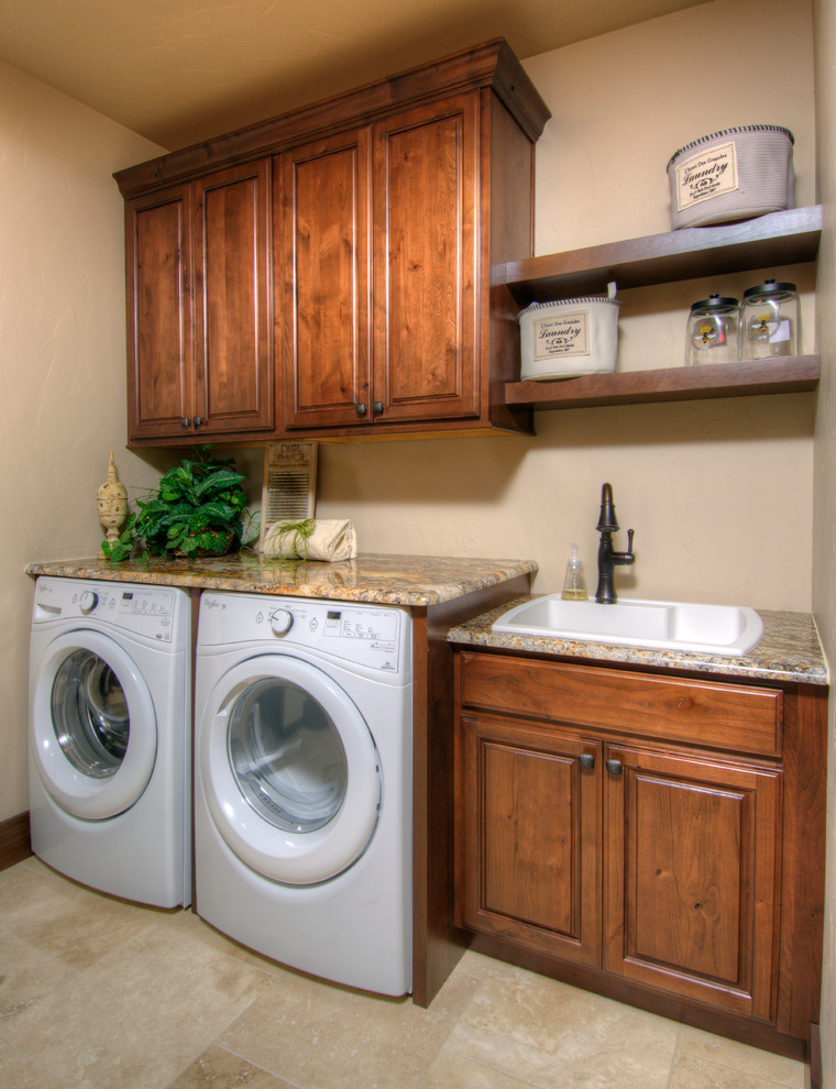 Einzeilige, Mittelgroße Klassische Waschküche mit Einbauwaschbecken, profilierten Schrankfronten, beiger Wandfarbe, Keramikboden, Waschmaschine und Trockner nebeneinander und dunklen Holzschränken in Denver