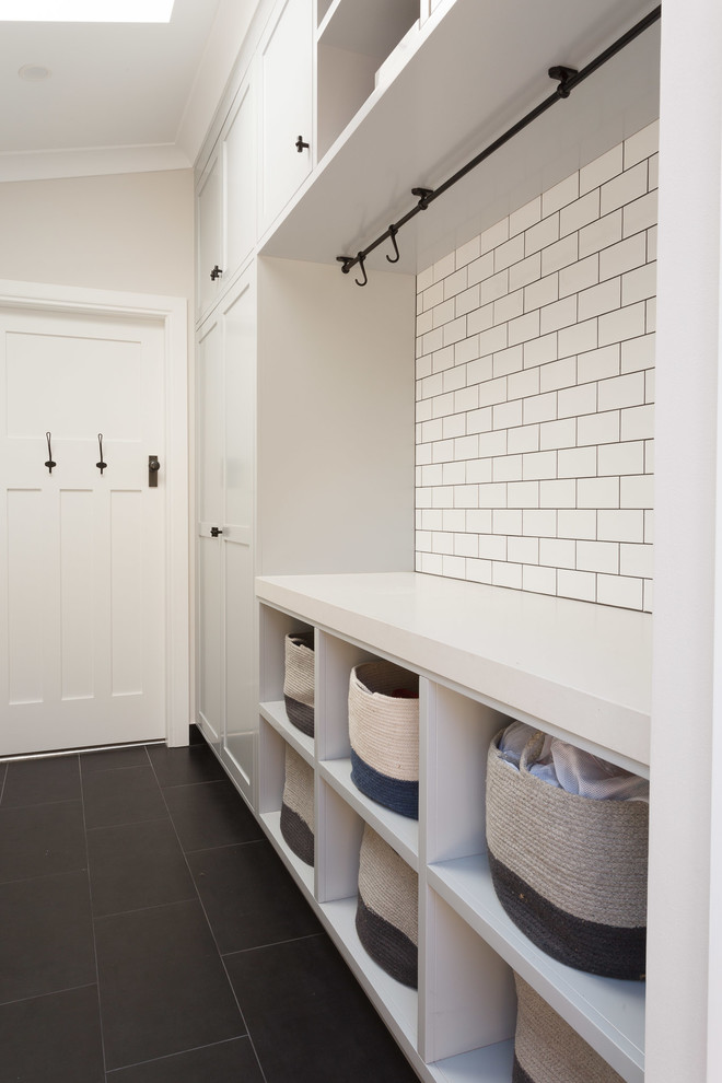 Ispirazione per una piccola sala lavanderia stile marinaro con ante lisce, ante bianche, pareti bianche, lavatrice e asciugatrice affiancate e pavimento nero