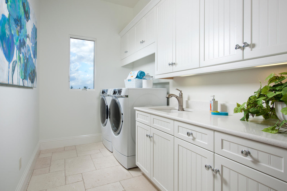 Idee per una sala lavanderia costiera con lavello sottopiano, ante bianche, pareti bianche, lavatrice e asciugatrice affiancate e ante con riquadro incassato