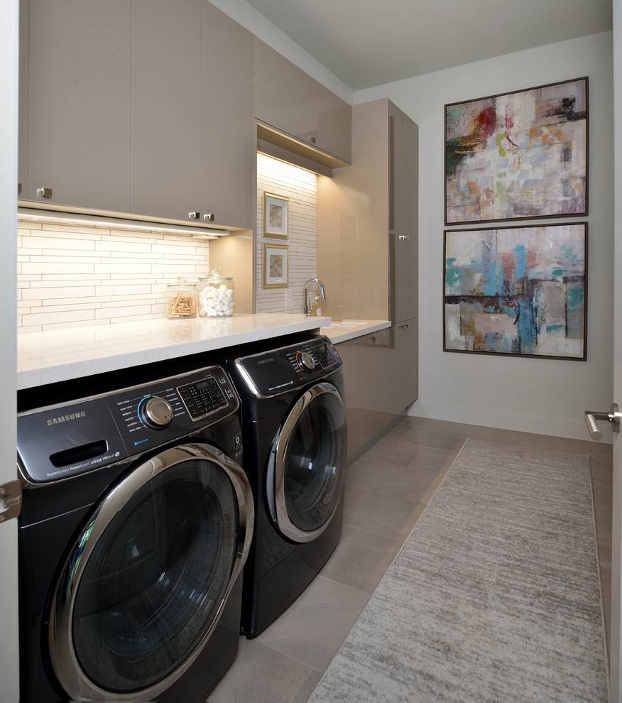 Ispirazione per una grande lavanderia moderna con lavello sottopiano, ante lisce, pareti grigie e pavimento grigio
