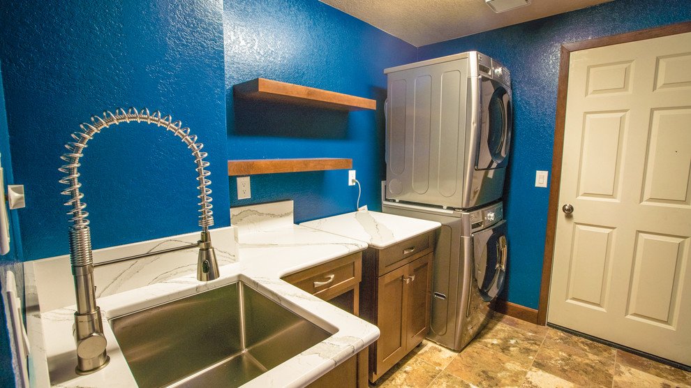 Ejemplo de lavadero tradicional renovado de tamaño medio con fregadero bajoencimera, encimera de cuarzo compacto, paredes azules, suelo laminado y lavadora y secadora apiladas