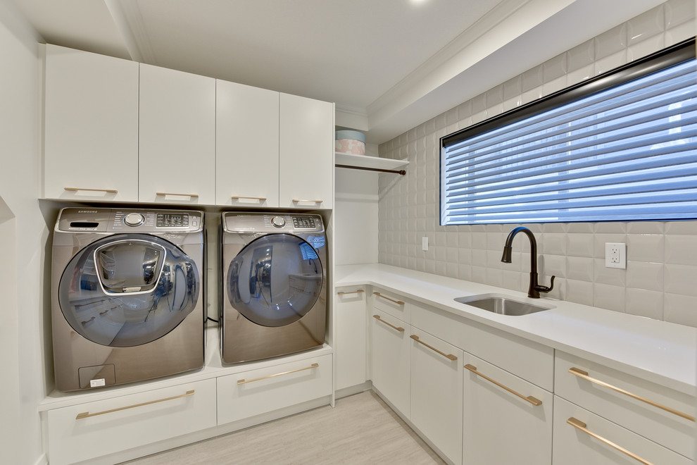 Large trendy l-shaped vinyl floor and beige floor utility room photo in Edmonton with an undermount sink, flat-panel cabinets, white cabinets, quartz countertops, white walls and a side-by-side washer/dryer
