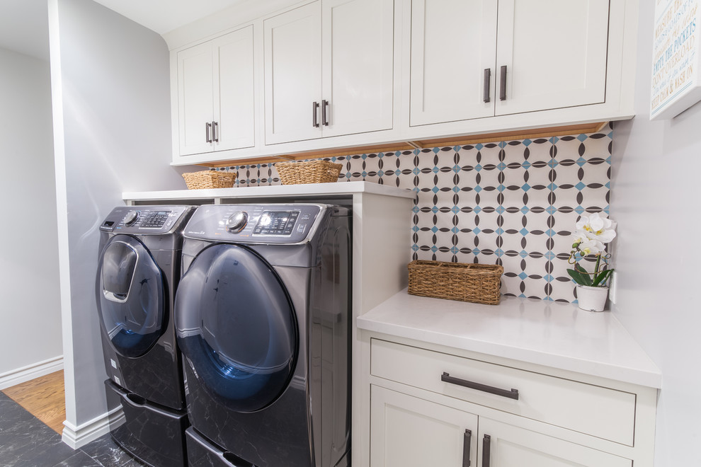 Inspiration for a mid-sized modern single-wall porcelain tile and black floor dedicated laundry room remodel in Los Angeles with shaker cabinets, white cabinets, quartz countertops, gray walls and a side-by-side washer/dryer