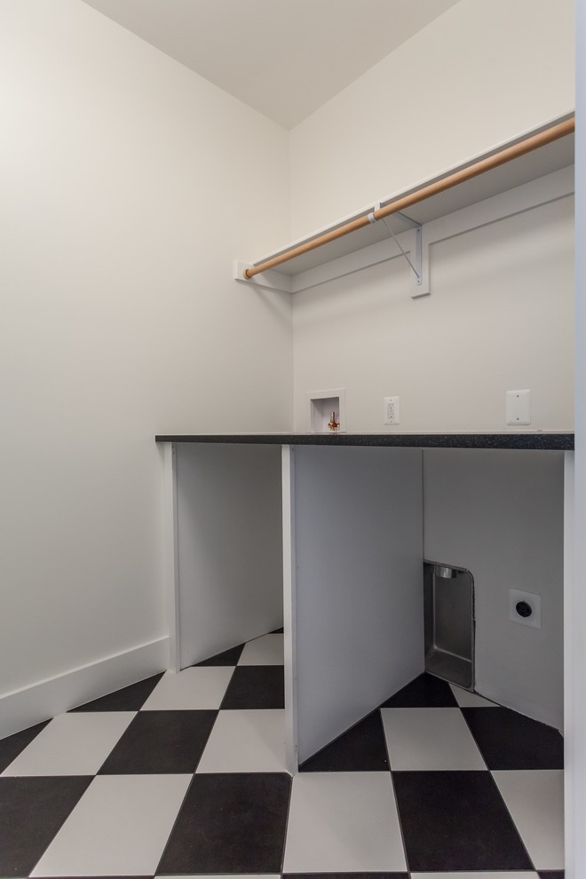 Inspiration for a contemporary galley separated utility room in DC Metro with a submerged sink, shaker cabinets, white cabinets, white walls, a side by side washer and dryer, multi-coloured floors and black worktops.