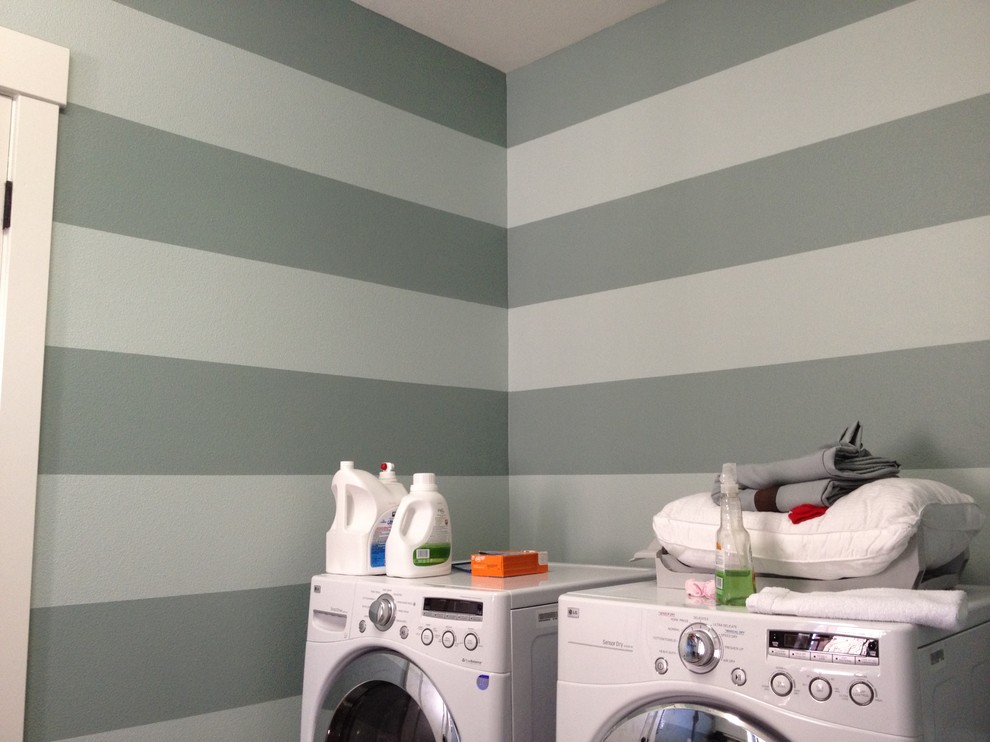 Foto på en vintage tvättstuga, med grå väggar och en tvättmaskin och torktumlare bredvid varandra