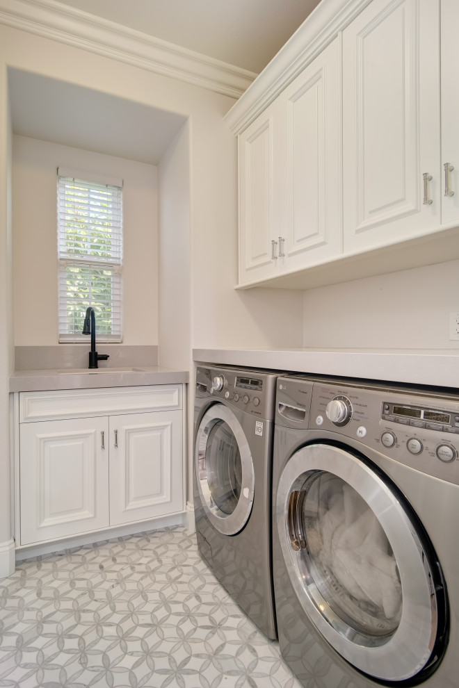 Idéer för en liten modern grå l-formad tvättstuga enbart för tvätt och med garderob, med en undermonterad diskho, luckor med upphöjd panel, vita skåp, bänkskiva i kvarts, vita väggar, marmorgolv och vitt golv