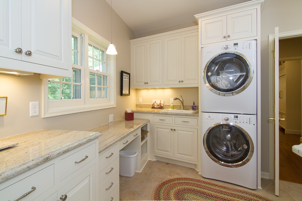 Foto di una lavanderia tradizionale con lavello da incasso, ante bianche, top in granito, pareti beige, pavimento con piastrelle in ceramica e lavatrice e asciugatrice a colonna