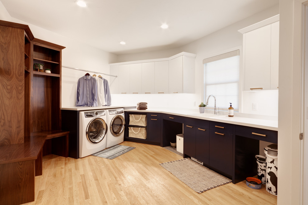 Design ideas for a large traditional utility room in Minneapolis with a submerged sink, recessed-panel cabinets, blue cabinets, laminate countertops, white walls, medium hardwood flooring, a side by side washer and dryer and multicoloured worktops.