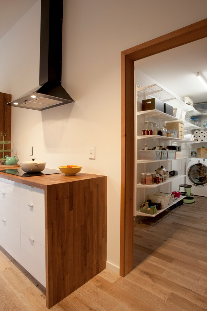 Multifunktionaler, Mittelgroßer Moderner Hauswirtschaftsraum in L-Form mit weißer Wandfarbe, hellem Holzboden und Waschmaschine und Trockner nebeneinander in San Francisco