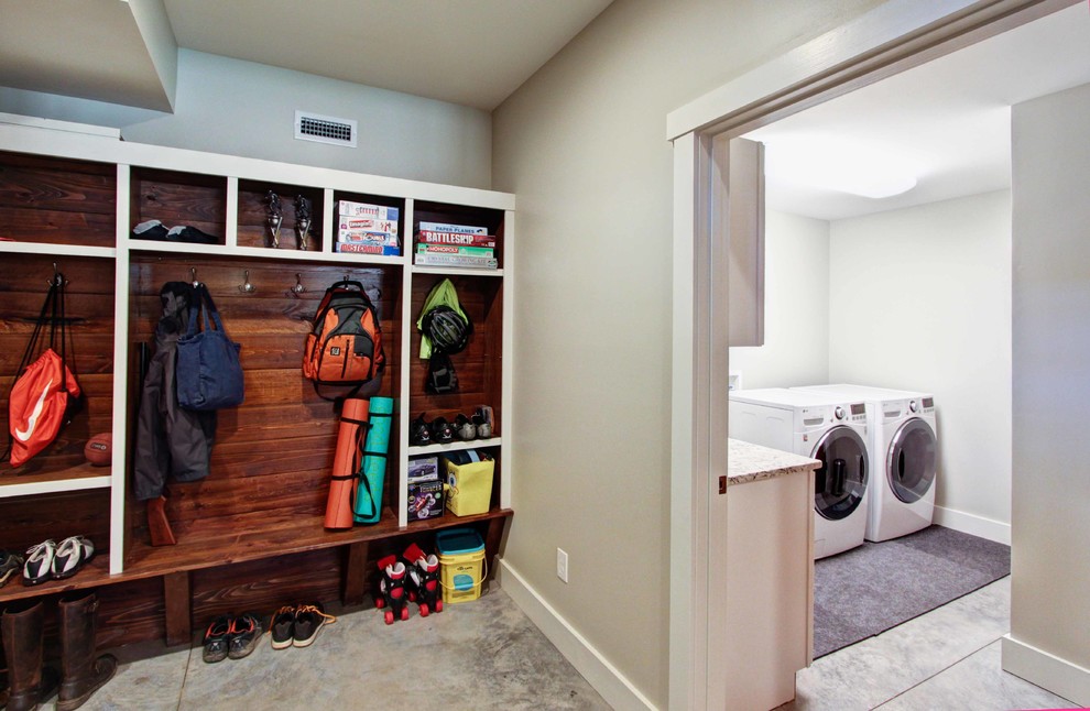 Trendy concrete floor laundry room photo in Other with a side-by-side washer/dryer
