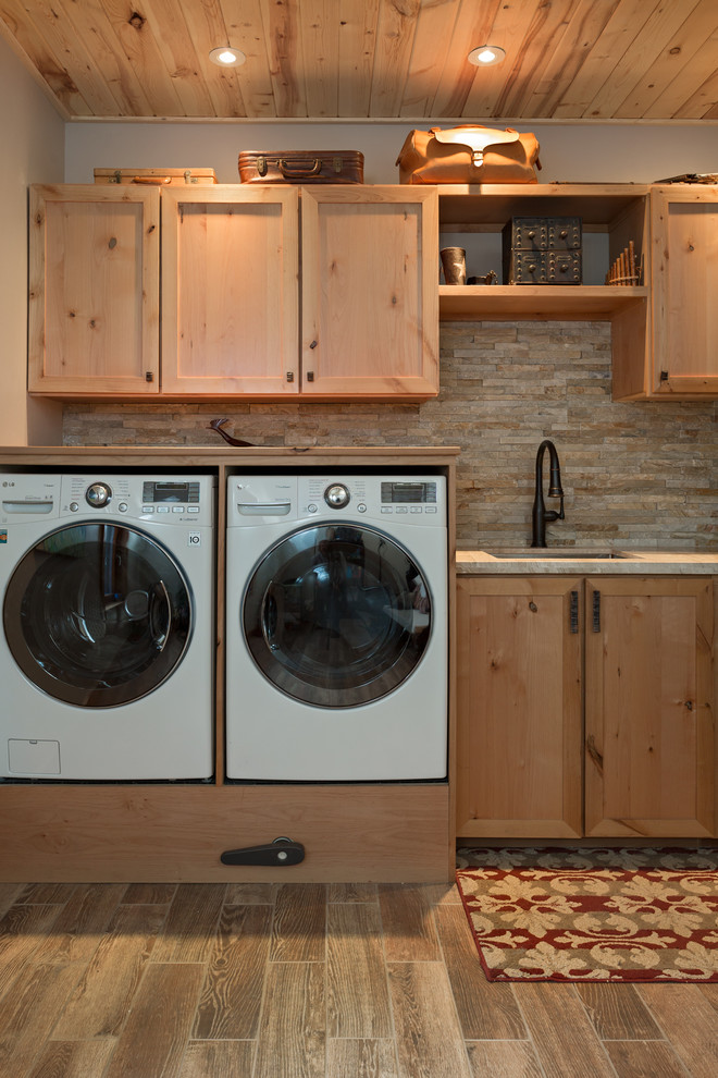 This is an example of a rustic utility room in Denver with shaker cabinets and a side by side washer and dryer.