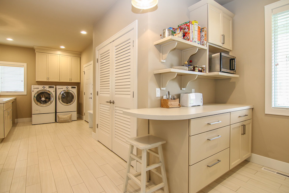 Imagen de lavadero multiusos costero grande con armarios estilo shaker, puertas de armario beige, paredes beige y lavadora y secadora juntas