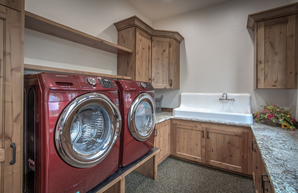 Inspiration for a medium sized rustic galley utility room in Seattle with a belfast sink, shaker cabinets, medium wood cabinets, granite worktops, white walls, limestone flooring and a side by side washer and dryer.