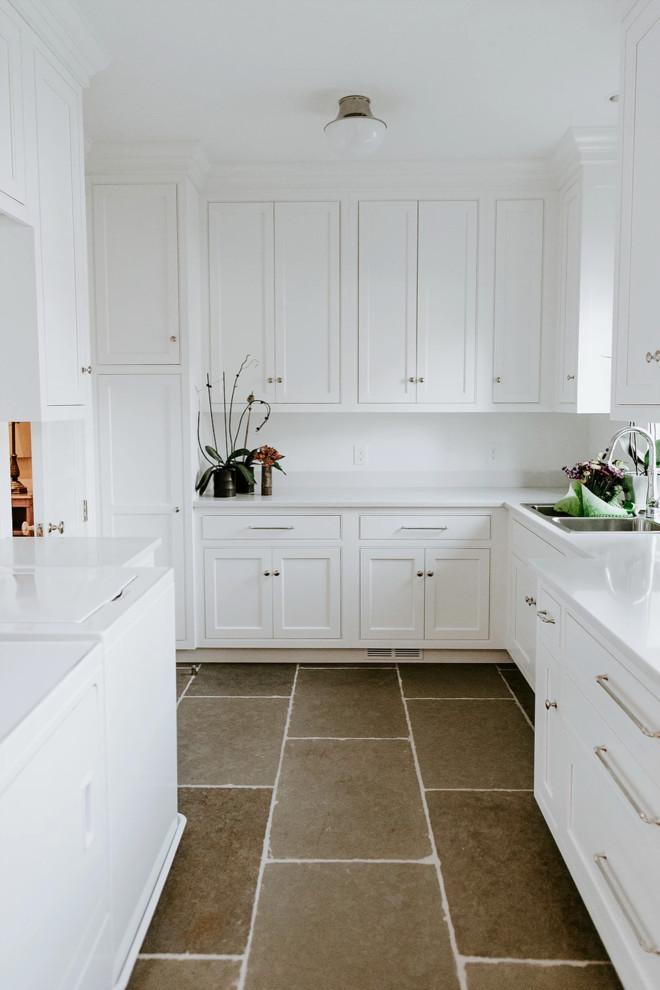 Esempio di una sala lavanderia contemporanea di medie dimensioni con lavello a doppia vasca, ante in stile shaker, ante bianche, pareti bianche, pavimento in ardesia, lavatrice e asciugatrice affiancate, pavimento marrone e top bianco